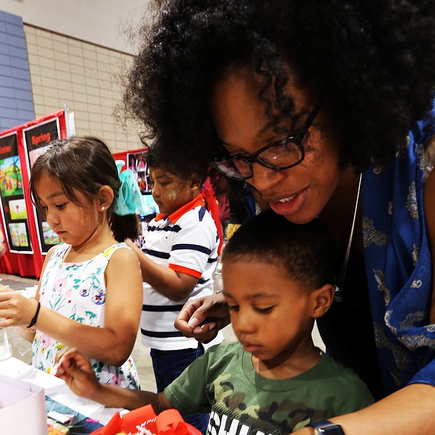 Celebrating Asian-American culture: Last Saturday the 22nd Annual Asian American Celebration featured food, music, performances, exhibits, games and educational crafts from a variety of Asian nations. Marcus Brown Jr., 4, and his mother, Lesli Brown, work on creating an Indonesian flower offering called a “Ganang Sari” at the Indonesian cultural activity booth during the festival. (Regina H. Boone/Richmond Free Press)