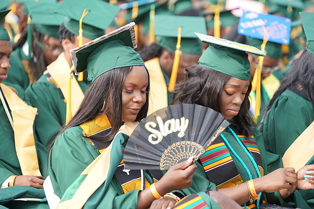 Behold the green and gold! Journalist Yamiche Alcindor, second from left, walks in Norfolk State University’s 104th Commencement procession last Saturday at Dick Price Stadium on the Norfolk campus with NSU Interim President Melvin T. Stith, left. Ms. Alcindor, White House correspondent for PBS NewsHour, was the commencement speaker during ceremonies at which nearly 500 students were awarded undergraduate or advanced degrees. Members of the 50th reunion Class of 1969 were recognized during the ceremony. The Class of 1969 was the first to graduate from Norfolk State College, which became an independent institution of higher education on Feb. 1, 1969. Dr. Javaune Adams-Gaston, a senior vice president at Ohio State University, is expected to take over as NSU’s seventh president in June. (Randy Singleton)