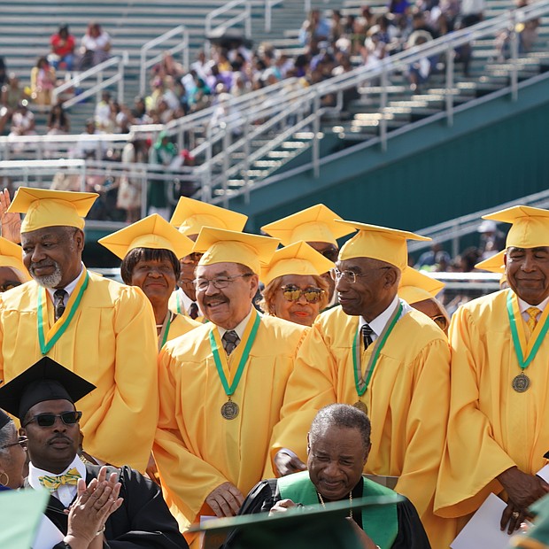 Behold the green and gold! Journalist Yamiche Alcindor, second from left, walks in Norfolk State University’s 104th Commencement procession last Saturday at Dick Price Stadium on the Norfolk campus with NSU Interim President Melvin T. Stith, left. Ms. Alcindor, White House correspondent for PBS NewsHour, was the commencement speaker during ceremonies at which nearly 500 students were awarded undergraduate or advanced degrees. Members of the 50th reunion Class of 1969 were recognized during the ceremony. The Class of 1969 was the first to graduate from Norfolk State College, which became an independent institution of higher education on Feb. 1, 1969. Dr. Javaune Adams-Gaston, a senior vice president at Ohio State University, is expected to take over as NSU’s seventh president in June. (Randy Singleton)