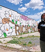 T. “Silly Genius” Sparks stands in front of the new mural that he and fellow muralist P.T. Carroll finished at 2604 Hull St., on the side of the Atlantis Food Service Equipment building. The two are among eight artists in the All City Art Club that began in 2017 to enliven neglected areas of the city. 
“Murals help make an area look better, then people feel better and then things will start to happen,” according to Silly Genius, who has led the club’s efforts to secure commissions. (Sandra Sellars/Richmond Free Press)