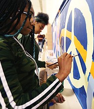 Speaking through art/John Marshall High School students Denaisja Jones, 16, left, and Nikisha Flemming, 15, put finishing touches on a 13-week mural project at the North Side school titled, “The Voices of John Marshall.” The students participate in ART180’s after-school community program, with the mural designed and created by 15 students with the co-leadership of local artist-volunteers Austin “Auz” Miles and Justice Dwight. It is one of 16 projects ART180 has throughout the city. (Regina H. Boone/Richmond Free Press)