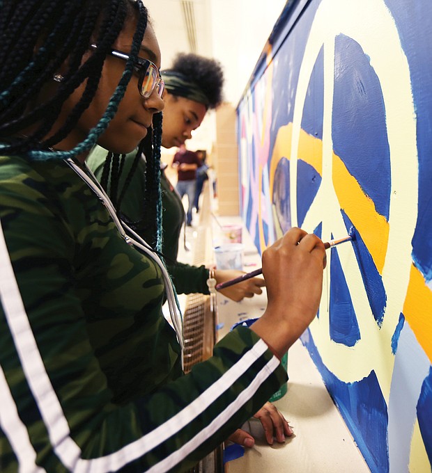 Speaking through art/John Marshall High School students Denaisja Jones, 16, left, and Nikisha Flemming, 15, put finishing touches on a 13-week mural project at the North Side school titled, “The Voices of John Marshall.” The students participate in ART180’s after-school community program, with the mural designed and created by 15 students with the co-leadership of local artist-volunteers Austin “Auz” Miles and Justice Dwight. It is one of 16 projects ART180 has throughout the city. (Regina H. Boone/Richmond Free Press)