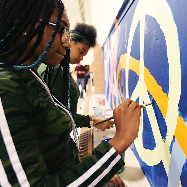 Speaking through art/John Marshall High School students Denaisja Jones, 16, left, and Nikisha Flemming, 15, put finishing touches on a 13-week mural project at the North Side school titled, “The Voices of John Marshall.” The students participate in ART180’s after-school community program, with the mural designed and created by 15 students with the co-leadership of local artist-volunteers Austin “Auz” Miles and Justice Dwight. It is one of 16 projects ART180 has throughout the city. (Regina H. Boone/Richmond Free Press)