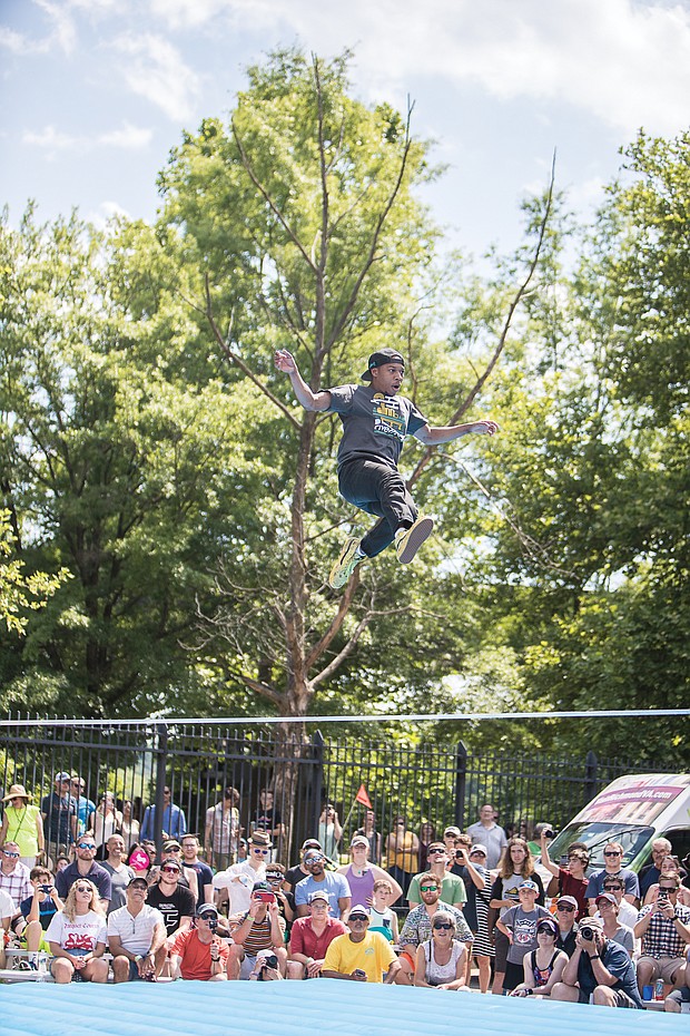 Riverrocking the James/An estimated 100,000 people flocked to Brown’s Island and the riverfront in Downtown last weekend for the Dominion Energy Riverrock festival. The three-day festival featured music, art and a range of sporting events and contests for people and dogs. Aaron Bray takes a leap during a slacklining event. (James Haskins/Richmond Free Press)