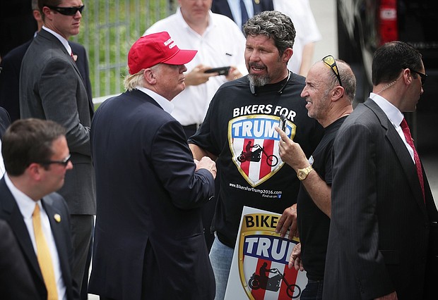 Republican presidential candidate Donald Trump greets with unidentified members of Bikers for Trump during the annual Rolling Thunder First Amendment Demonstration Run May 29, 2016 in Washington, DC. Bikers are gathering in the annual parade in the nation's capital to remember those who were prisoners of war and missing in action on Memorial Day weekend.