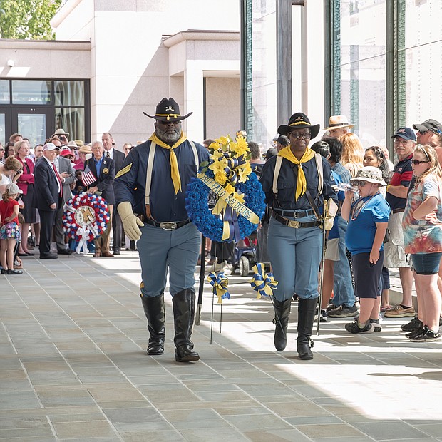 Celebrations of remembrance on Memorial Weekend/
Eddie Rose and Patricia Williams of the Mark Matthews Chapter of Petersburg, 9th and 10th Cavalry of the Buffalo Soldiers Association carry a wreath to be placed at the feet of the statue of Memory during Monday’s 63rd Annual Commonwealth’s Memorial Day Ceremony at the Virginia War Memorial on South Belvidere Street in Downtown. (Ava Reaves/Richmond Free Press)