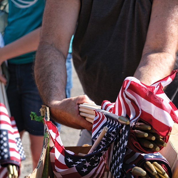 Celebrations of remembrance on Memorial Weekend/
On Saturday, John Harris distributes American flags, above right, to volunteers who placed them beside the graves of veterans buried at historic Evergreen Cemetery in the East End. (Sandra Sellars/Richmond Free Press)