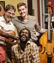 Keydron Dunn, seated, shares a laugh with Ralph Seligmann, left, who wrote “Minerva Times Change” and his son, Niccolo Seligmann, who created the music.