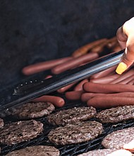 Celebrations of remembrance and fun on Memorial Weekend/
Hot dogs and hamburgers sizzle on the grill at the 3rd Annual Cookout for a Cause at Westover Hills Elementary School in School Side. Handling chef duties for the free event on Saturday is Nina Tucker of Nomad Deli in Highland Park. (Sandra Sellars/Richmond Free Press)