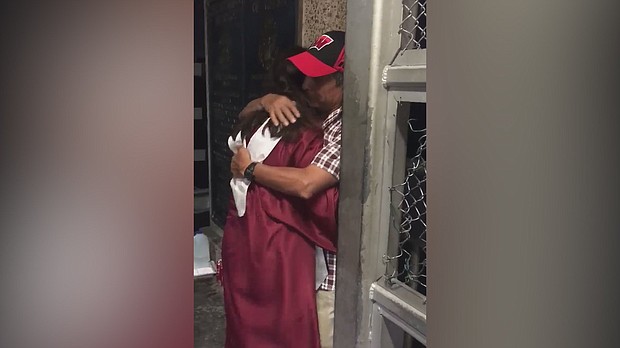 Sarai Ruiz embraces her father on a border bridge in her cap and gown, because her father couldn't attend her graduation.