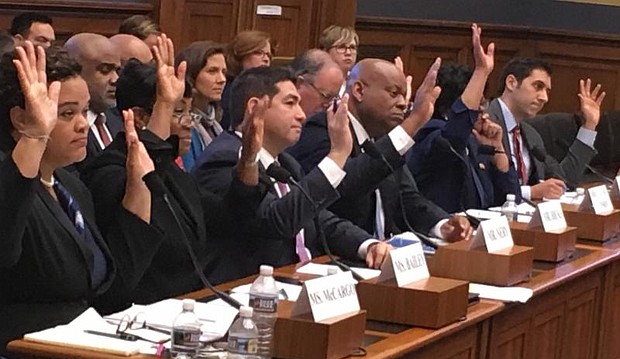 After hours of testimony before the House Finance Committee's Subcommittee on Housing, Community Development and Insurance, witnesses raise their hands in response to a question on whether homeownership discrimination against Blacks continues today. Seated left to right are: Alanna McCargo, vice president for Housing Finance Policy, Urban Institute; Nikitra Bailey, executive vice president, Center for Responsible Lending; Joseph Nery, president, National Association of Hispanic Real Estate Professionals; Jeff Hicks, president/CEO; National Association of Black Real Estate Brokers (NAREB); Carmen Castro, managing housing counselor, Housing Initiative Partnership; Joanne Poole, liaison for the National Association of Realtors; and Joel Griffith, research fellow, Financial Regulations, The Heritage Foundation. PHOTO: Hazel Trice Edney