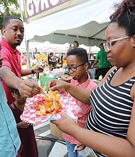 Broad Appétit dishes out food, fun/
Thousands turned out to sample the offerings of 60 plus Richmond area chefs at the 12th edition of Broad Appétit, a food festival like no other. The Clarke family from Chester share a plate of “butterfly chips.” 
Sunday’s event once again created a palate-tickling paradise in four blocks of Broad Street between Adams and Henry streets in Downtown. 
Participants ponied up $4 for each sample they taste-tested, with proceeds from the festive event benefiting FeedMore and the Central Virginia Food Bank. 
Along with mouth-watering treats, the event also featured live music and an art project for children. (Regina H. Boone/Richmond Free Press)