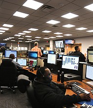 Cityscape/It took 16 months and $2.8 million to build. 
Now Richmond’s new training center for emergency dispatchers is ready for use at 3516 N. Hopkins Road.
The new 4,300-square-foot addition was dedicated May 30, bringing the total square footage of the building to 19,300. 
Dispatchers work in the building's existing operations center during an open house where tours showed the similar equipment set up in the new training center.  (Regina H. Boone/Richmond Free Press)