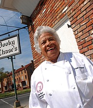 In this March 2007 photo, Leah Chase stands outside of her famous New Orleans restaurant, Dooky Chase’s, that was started by her husband’s family in the early 1940s.