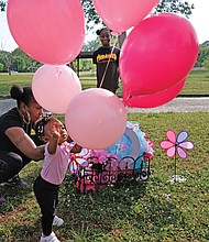 Marquita Ridley, left, and her daughters, Nyirah Phillips, 10, and Blessyn Evans place balloons Wednesday on a memorial at Carter Jones Park in South Side, where 9-year-old Markiya Dickson was fatally shot on May 26. Markiya’s family is hosting a vigil at the park on Bainbridge Street at 5:30 p.m. Thursday, June 6