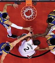 Kawhi Leonard of the Toronto Raptors, wearing the No. 2 jersey, is surrounded by Golden State Warriors’ defenders Shaun Livingston, No. 34; Steph Curry, No. 30; Quinn Cook, No. 4; and Draymond Green, No. 23, during the second half of Sunday’s Game 2 of the NBA Finals.