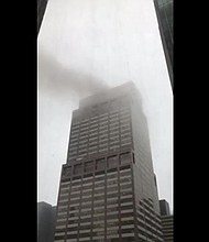 A helicopter made a hard landing on the roof of a building in Manhattan and a fire ensued, New York Gov. Andrew Cuomo said Monday. In this image, smoke appears to be rising out of the building in Manhattan where the helicopter crashed.