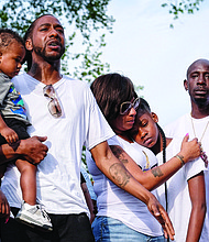 The family of 9-year-old Markiya Dickson grieves during a vigil June 6 at Carter Jones Park, where the youngster was shot and killed. They are, from left, her dad, Mark Whitfield Sr., who is holding young Mark Jr.; mother Ciara Dickson; sister Samaya Dickson; and uncle Dion Tuell. (Sandra Sellars/Richmond Free Press)
