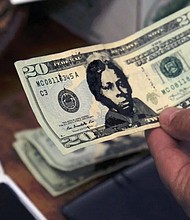 A U.S. $20 bill from the offering plate at Hope Central Church in Boston is stamped with the face of abolitionist Harriet Tubman on June 2.