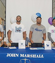 Four John Marshall basketball players reveal their college choices at a ceremony June 5 at the North Side high school. They are, from left, Aubrey Merritt, DeMarr McRae, Levar Allen and Tre Harris-McKenzie.