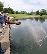 Farewell to a friend: Left, Greg Roland and other comrades of George Edward “Buster” Booth scatter his ashes May 29 in Byrd Park’s Swan Lake in a final farewell to a lifelong friend. Below left, James “Plunky” Branch, one of the close-knit group that grew up together in Richmond’s Randolph and Maymont neighborhoods, plays “Amazing Grace” on his saxophone ahead of the ash-scattering ceremony. Below right, a small memorial includes Mr. Booth’s obituary and photo. Former NBA star Bobby Dandridge and the Rev. Robert Winfree, who preached Mr. Booth’s eulogy, are among those who attended the ceremony that began at Byrd Park’s Shelter No. 1, one of Mr. Booth’s favorite places. Every year around Mr. Booth’s May 26 birthday, his friends would bring the longtime paraplegic to the shelter for an outing. Mr. Booth died Nov. 6, 2018, but friends waited to scatter his ashes near what would have been his 72nd birthday. Longtime friend Jerome F. Hughes, who helped organize the ceremony, said Swan Lake was chosen because as children, they were banned from what was then a whites-only place to swim. (Regina H. Boone/Richmond Free Press)