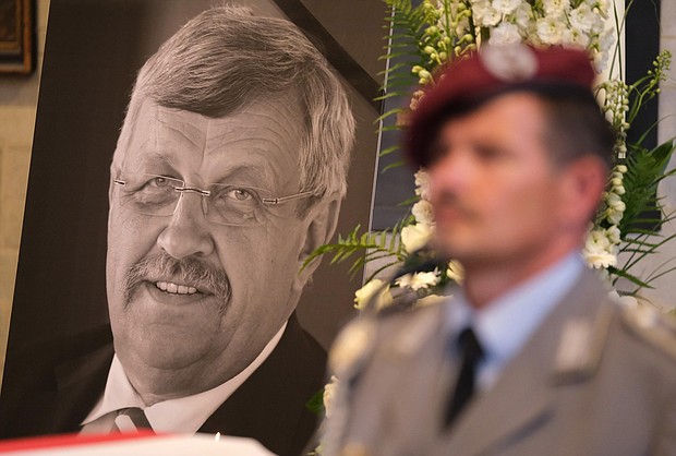 An honor guard stands at a portrait and coffin of murdered German politician Walter Lübcke.