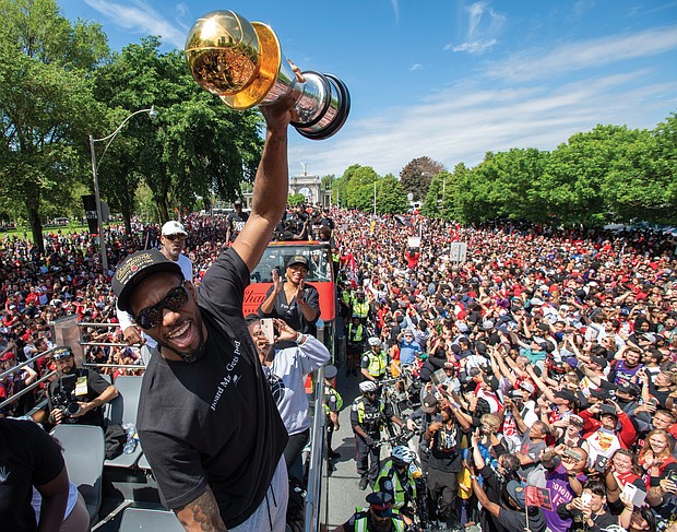 Kawhi Leonard leads the celebration as the Toronto Raptors parade through a sea of adoring fans Monday after upsetting the Golden State Warriors to secure their first NBA title.