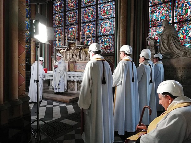 The Archbishop of Paris, Michel Aupetit, second from left, leads the first Mass in a side chapel on June 15, two months after a devastating fire engulfed the Notre Dame Cathedral in Paris.