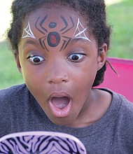 The big reveal/
Ahkbar Jordan, 6, reacts to seeing how his face was painted by artist Kenita Wooten last Saturday during “Juneteenth: A Freedom Celebration” at Manchester Dock in South Side. The three-day festival featured a bevy of fun and educational events. (Sandra Sellars/Richmond Free Press)