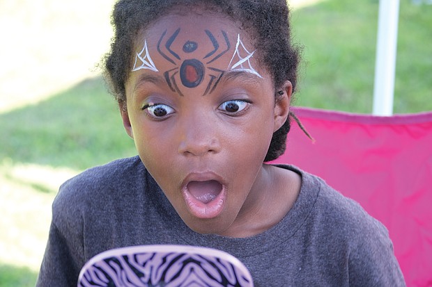 The big reveal/
Ahkbar Jordan, 6, reacts to seeing how his face was painted by artist Kenita Wooten last Saturday during “Juneteenth: A Freedom Celebration” at Manchester Dock in South Side. The three-day festival featured a bevy of fun and educational events. (Sandra Sellars/Richmond Free Press)