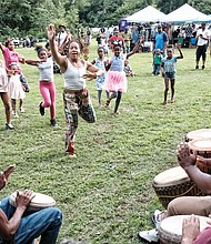 Celebrating Juneteenth/
Hundreds of people enjoy activities last Saturday at “Juneteenth: A Freedom Celebration” on the waterfront of the James River in South Side at the Manchester Dock. The three-day event, organized by the Elegba Folklore Society and its founder, Janine Y. Bell, marks the date on June 19, 1865, when enslaved people in Texas learned of their freedom after the defeat of the Confederates and Union forces took control of that state. Richmond’s celebration included educational sessions for people of all ages to learn about Africans brought to this nation 400 years ago and their struggles and contributions. At Saturday’s events, called “Independence Day Our Way,”  Imani Bell, left, teaches youngsters African dances with the accompaniment of drummers. (Sandra Sellars/Richmond Free Press)