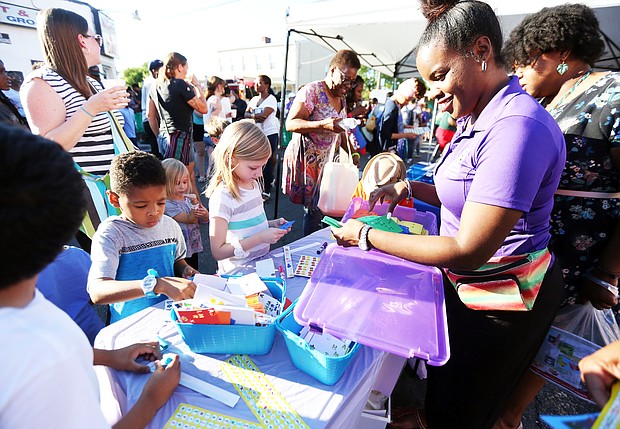 ‘In The Sun Again’
At the Robinson Theater Community Arts Center’s “In The Sun Again Community Block Party” last Friday at the Church Hill, Karen Wells, right, introduces children to art activities at the PBS “Ready to Learn” table in her role as East End manager for the PBS program. The block party continues the theater’s efforts to be a place that creates connections between residents and supports diversity and inclusion. (Regina H. Boone/Richmond Free Press)