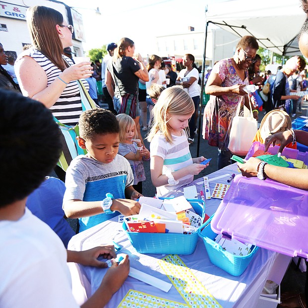 ‘In The Sun Again’
At the Robinson Theater Community Arts Center’s “In The Sun Again Community Block Party” last Friday at the Church Hill, Karen Wells, right, introduces children to art activities at the PBS “Ready to Learn” table in her role as East End manager for the PBS program. The block party continues the theater’s efforts to be a place that creates connections between residents and supports diversity and inclusion. (Regina H. Boone/Richmond Free Press)