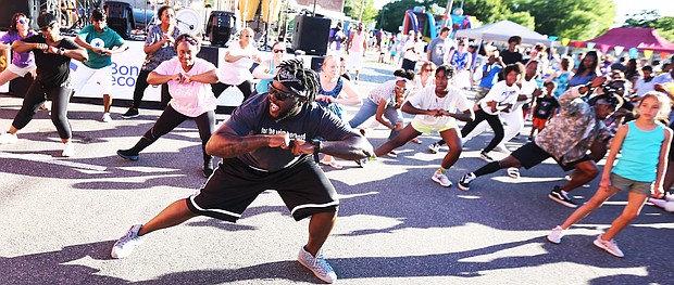 'In the Sun Again'/
Me’Kel Williams leads a cardio hip-hop session during the Robinson Theater Community Arts Center’s “In The Sun Again Community Block Party” last Friday at the Church Hill center. Mr. Williams demonstrated the workout he leads weekly at the center, where he is assistant director.  The block party continues the theater’s efforts to be a place that creates connections between residents and supports diversity and inclusion. (Regina H. Boone/Richmond Free Press)