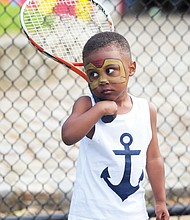 New to the game/
Darien Threatts, 2, channels his inner Ashe during a tennis skills session for children last Saturday at Battery Park in North Side. Friends of Battery Park collaborated with several other groups to put on the celebration at the park’s Arthur Ashe Tennis Courts. (Regina H. Boone/Richmond Free Press)