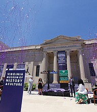 Streamers fly as the new Arthur Ashe Boulevard street signs are unveiled last Saturday by David O. Harris Jr., nephew of Arthur Ashe, left, City Councilwoman Kim B. Gray and Mayor Levar M. Stoney at the Virginia Museum of History & Culture.