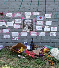 Tributes to Brandon Robertson, who died June 27, are left beside Jade Multicultural Salon at 3304 E. Marshall St., where Mr. Robertson and a friend previously created a mural.