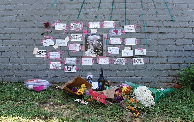 Tributes to Brandon Robertson, who died June 27, are left beside Jade Multicultural Salon at 3304 E. Marshall St., where Mr. Robertson and a friend previously created a mural.