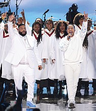 DJ Khaled and John Legend stand in front of a choir to lead a musical tribute to Nipsey Hussle during the BET Awards on June 23 at Microsoft Theater in Los Angeles.