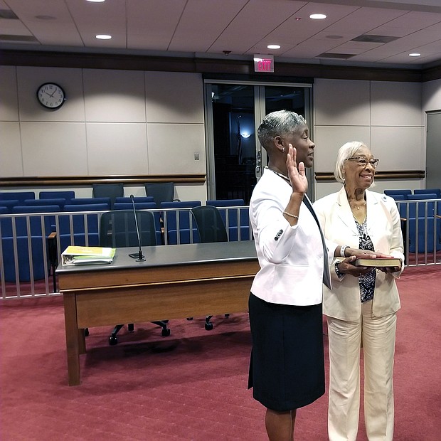 Colette W. McEachin is sworn in as Richmond’s new commonwealth’s attorney Tuesday morning by Judge Joi Jeter Taylor, chief judge of the Richmond Circuit Court, as Mrs. McEachin’s proud mother, Gladys Wallace, holds the Bible. Mrs. McEachin’s husband, Congressman A. Donald McEachin of Richmond, Richmond Circuit Court Clerk Edward F. Jewett and several of Mrs. McEachin’s deputy commonwealth’s attorneys also attended the ceremony at the John Marshall Courts Building in Downtown. Mrs. McEachin, who has more than 20 years of experience as a city prosecutor, took over the top job after veteran Commonwealth’s Attorney Michael N. Herring left July 1 to become a partner in the McGuireWoods law firm. Mr. Herring, who recommended Mrs. McEachin for the top post, is backing her in the Nov. 5 special election when voters will formally choose his successor.