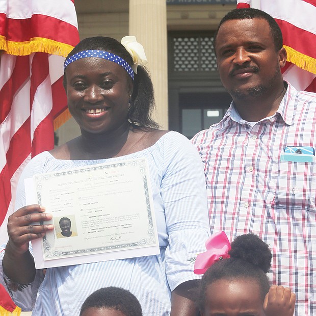 New U.S. citizens
About 100 people from nearly 50 countries took the oath of allegiance to become U.S. citizens during an Independence Day ceremony outside the Virginia Museum of History & Culture in Richmond. Chief Judge Roger L. Gregory of the 4th U.S. Circuit Court of Appeals presided over the ceremony and administered the oath as family, friends and area residents watched. Felicia Baffour of Ghana shows off her new citizenship documents as she stands with her husband, Dave Baffour, and their children, Jaiden and Victoria. The family lives in Fredericksburg. (Regina H. Boone/Richmond Free Press)