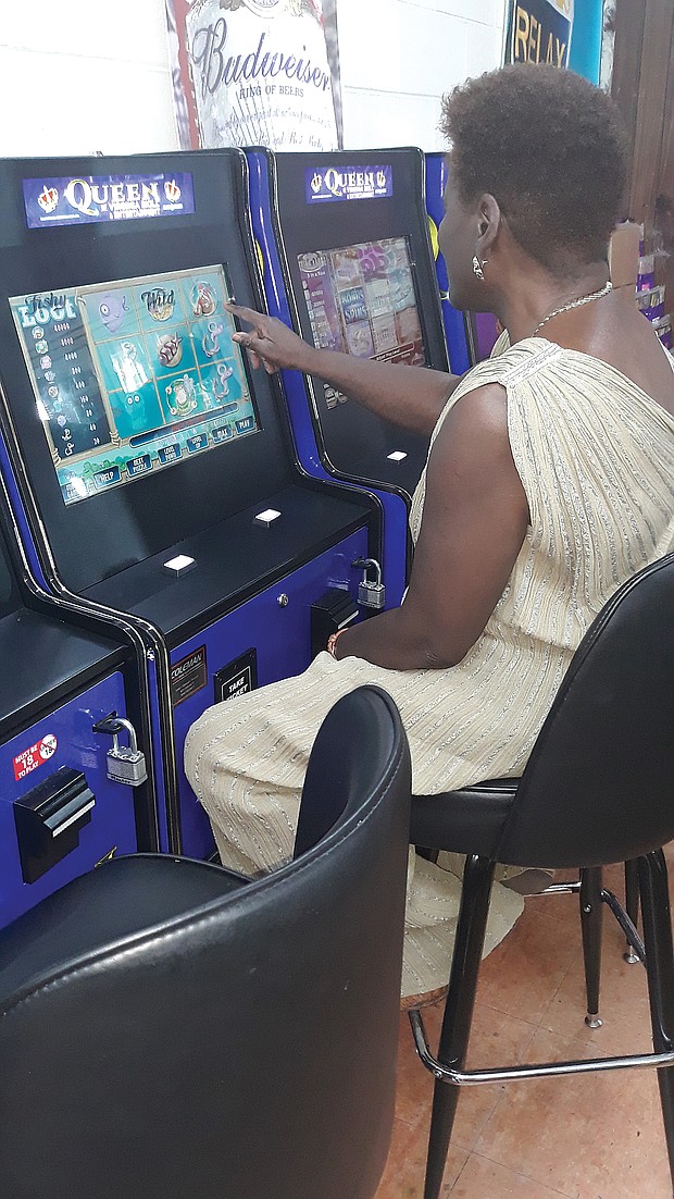 Dr. Joann Henry plays at a bank of slot machines at the Quick N Easy convenience store in the 4100 block of West Broad Street.