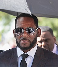 R. Kelly is charged with sex trafficking in New York and attempting to influence a case in Atlanta, and was arrested while walking his dog, a source with knowledge of the arrest said.