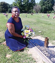 Adeline U. Clarke kneels beside the recently installed marker at her parents’ gravesite in Forest Lawn Cemetery in Henrico County. She finished paying for the marker in November, but had to badger the cemetery for months before it was installed.