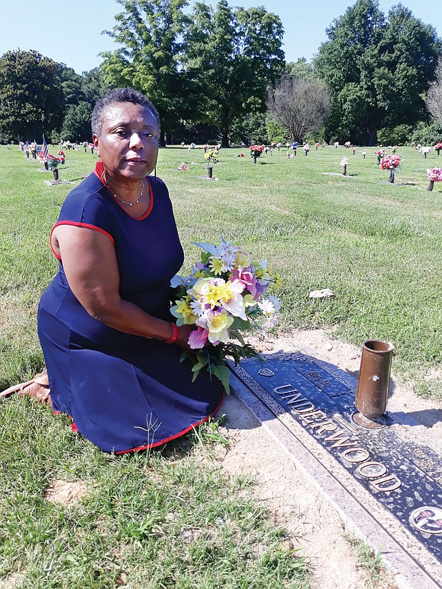 Adeline U. Clarke kneels beside the recently installed marker at her parents’ gravesite in Forest Lawn Cemetery in Henrico County. She finished paying for the marker in November, but had to badger the cemetery for months before it was installed.