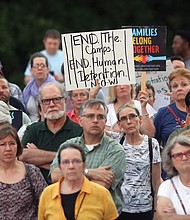 A crowded scene from last Friday’s “Lights for Liberty” vigil on the State Capitol grounds calling for an end to the detention camps and family separations imposed on migrants to the United States along the southern border. Hundreds of people attended the vigil, which was sponsored by numerous Richmond area organizations, including Indivisible Virginia, the Virginia ACLU, UndocuRams and ReEstablish Richmond. Local activists, advocates and others spoke at the event, which was one of nearly 700 Lights for Liberty events held around the globe. Bridgette Newberry, an art teacher in Richmond, held her sign aloft in the crowd. (Regina H. Boone/Richmond Free Press)