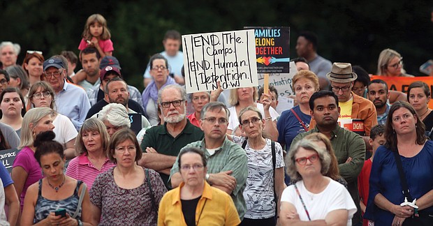 A crowded scene from last Friday’s “Lights for Liberty” vigil on the State Capitol grounds calling for an end to the detention camps and family separations imposed on migrants to the United States along the southern border. Hundreds of people attended the vigil, which was sponsored by numerous Richmond area organizations, including Indivisible Virginia, the Virginia ACLU, UndocuRams and ReEstablish Richmond. Local activists, advocates and others spoke at the event, which was one of nearly 700 Lights for Liberty events held around the globe. Bridgette Newberry, an art teacher in Richmond, held her sign aloft in the crowd. (Regina H. Boone/Richmond Free Press)