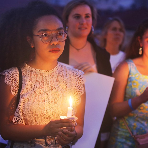 Adele McClure, left, holds a candle during last Friday’s “Lights for Liberty” vigil on the State Capitol grounds calling for an end to the detention camps and family separations imposed on migrants to the United States along the southern border. Hundreds of people attended the vigil, which was sponsored by numerous Richmond area organizations, including Indivisible Virginia, the Virginia ACLU, UndocuRams and ReEstablish Richmond. Local activists, advocates and others spoke at the event, which was one of nearly 700 Lights for Liberty events held around the globe. (Regina H. Boone/Richmond Free Press)