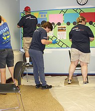 A team of Capital One volunteers from Richmond, Northern Virginia, Maryland, Delaware, New Jersey, New York, New Orleans and Texas put a fresh coat of paint on a new office for the principal at Fairfield Court Elementary School on Wednesday as a part of RPS Shines 2019.