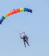 a sky diver parachutes onto the field at The Diamond before the game on July 10.